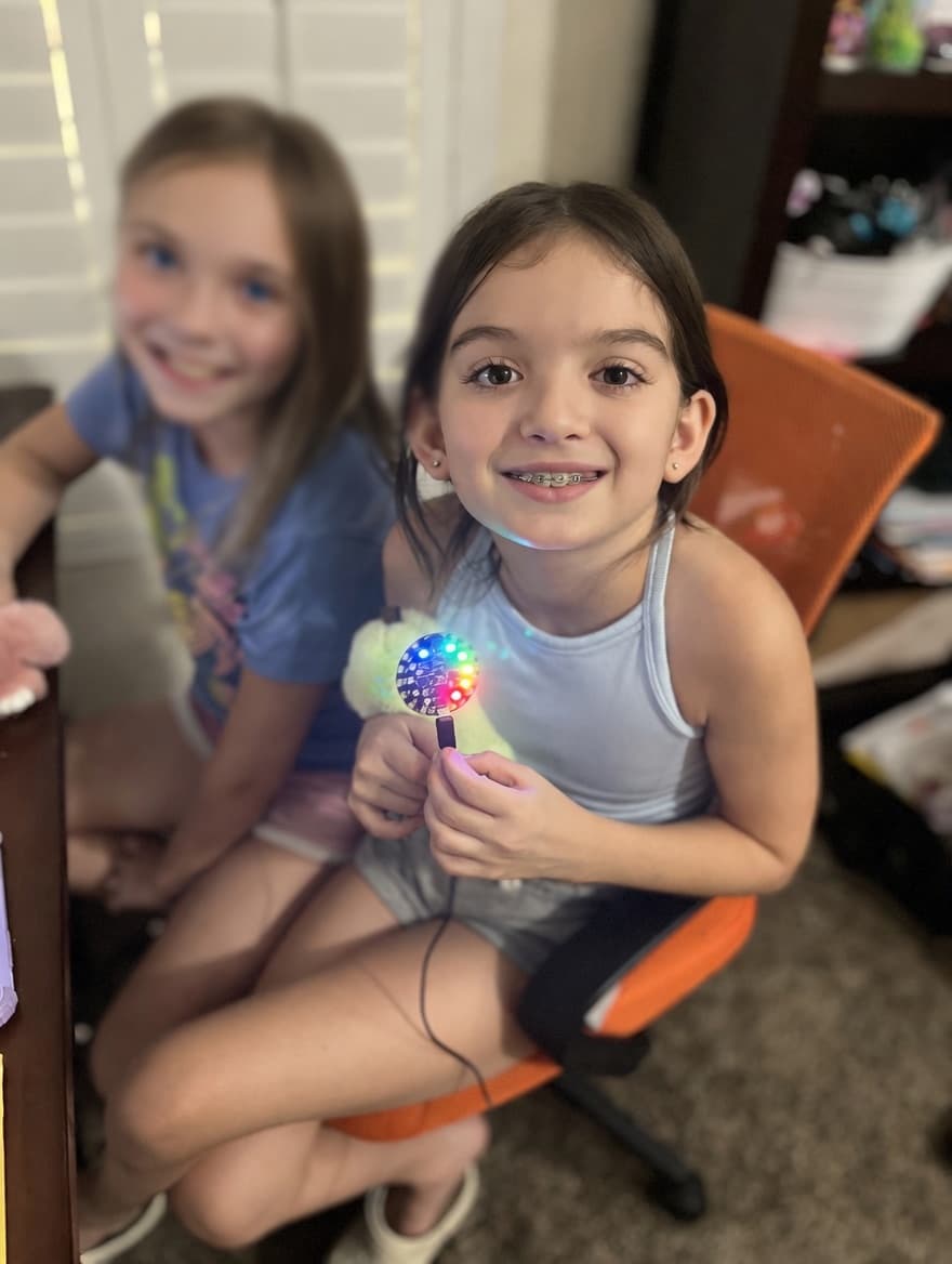 Student holding a lit-up Circuit Playground board